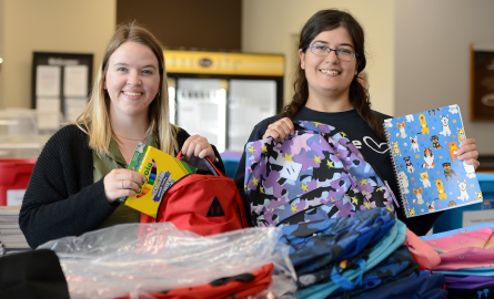 two people packing backpacks