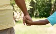 A parent holding a child's hand