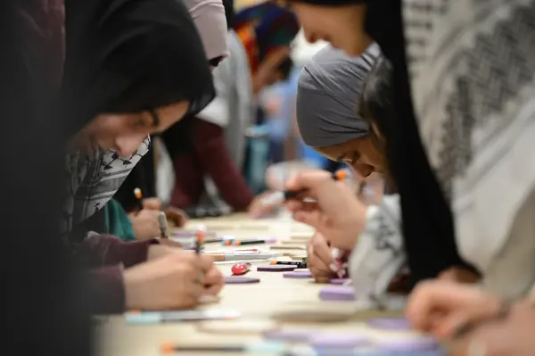 Students writing on purple hexagons at the Muslim Excellence Student Leadership Conference